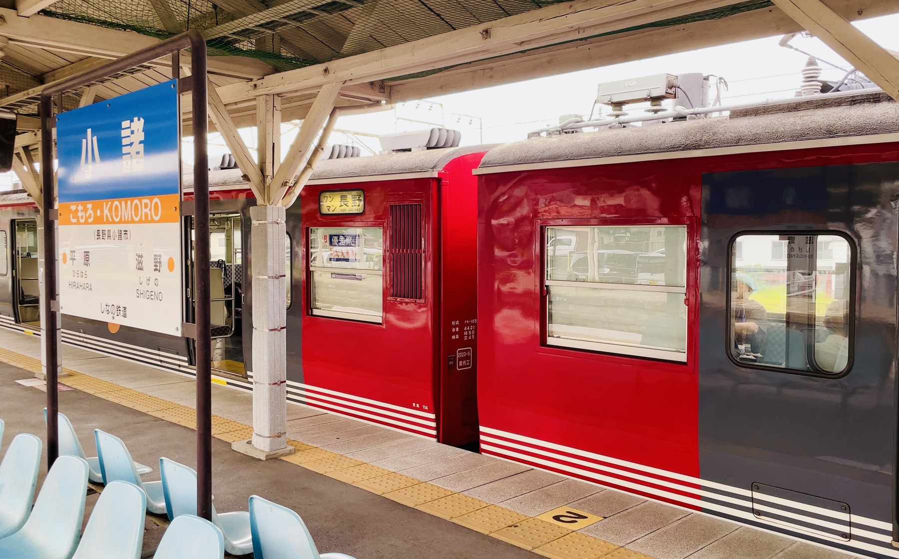 A red train at the platform of Komoro Station